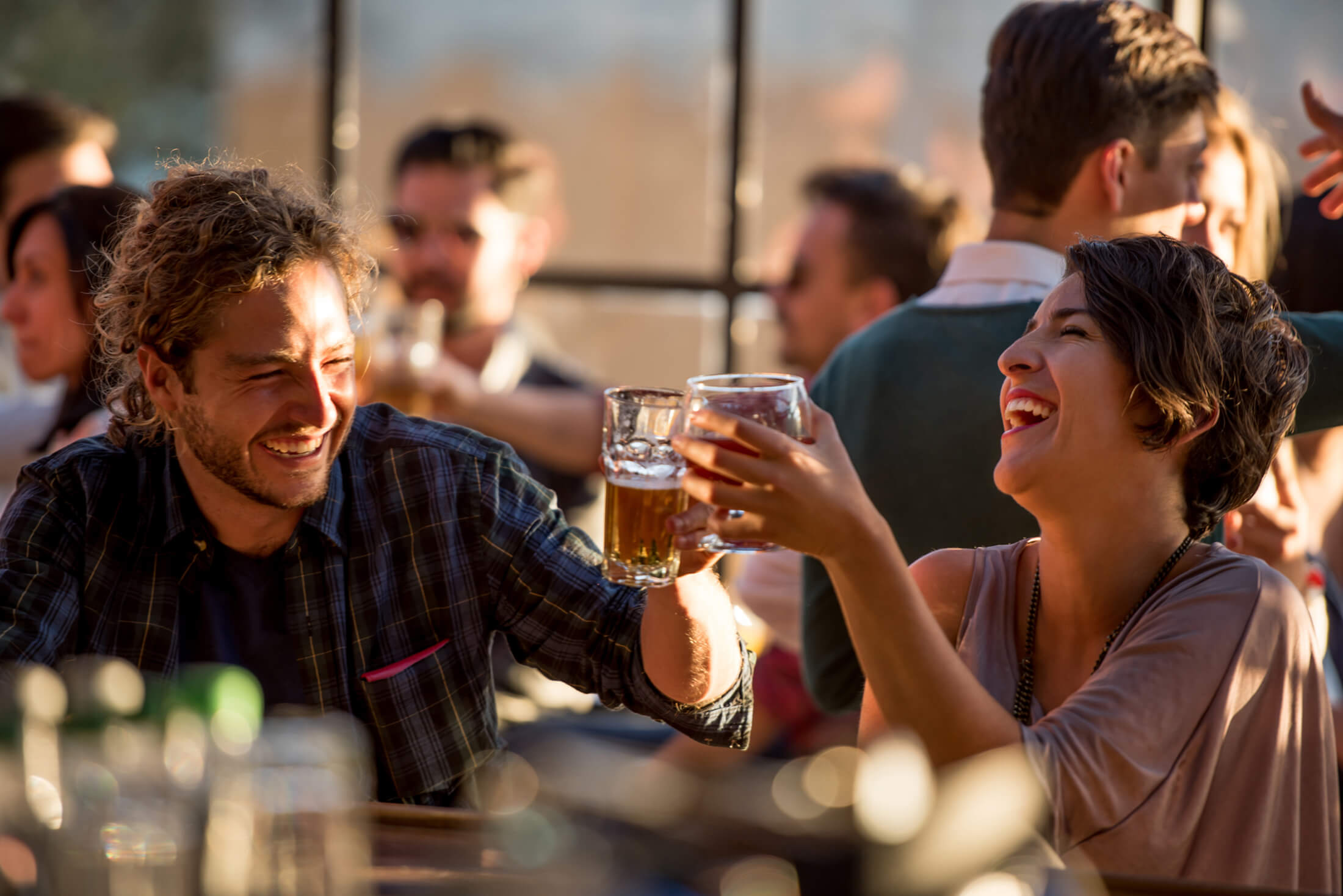 A man and a women laughing while drinking beer