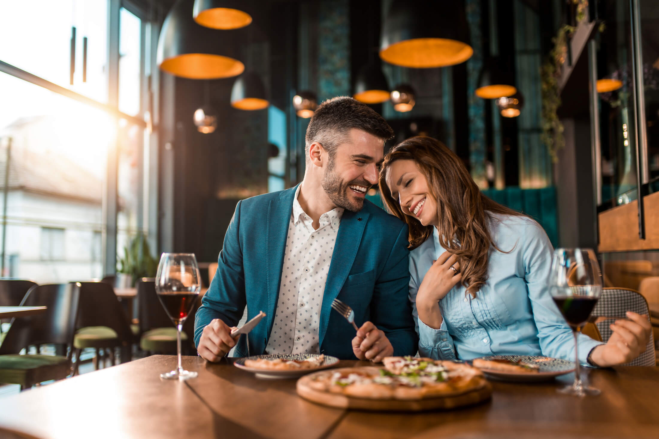 a couple enjoying pizza an in upscale dining setting