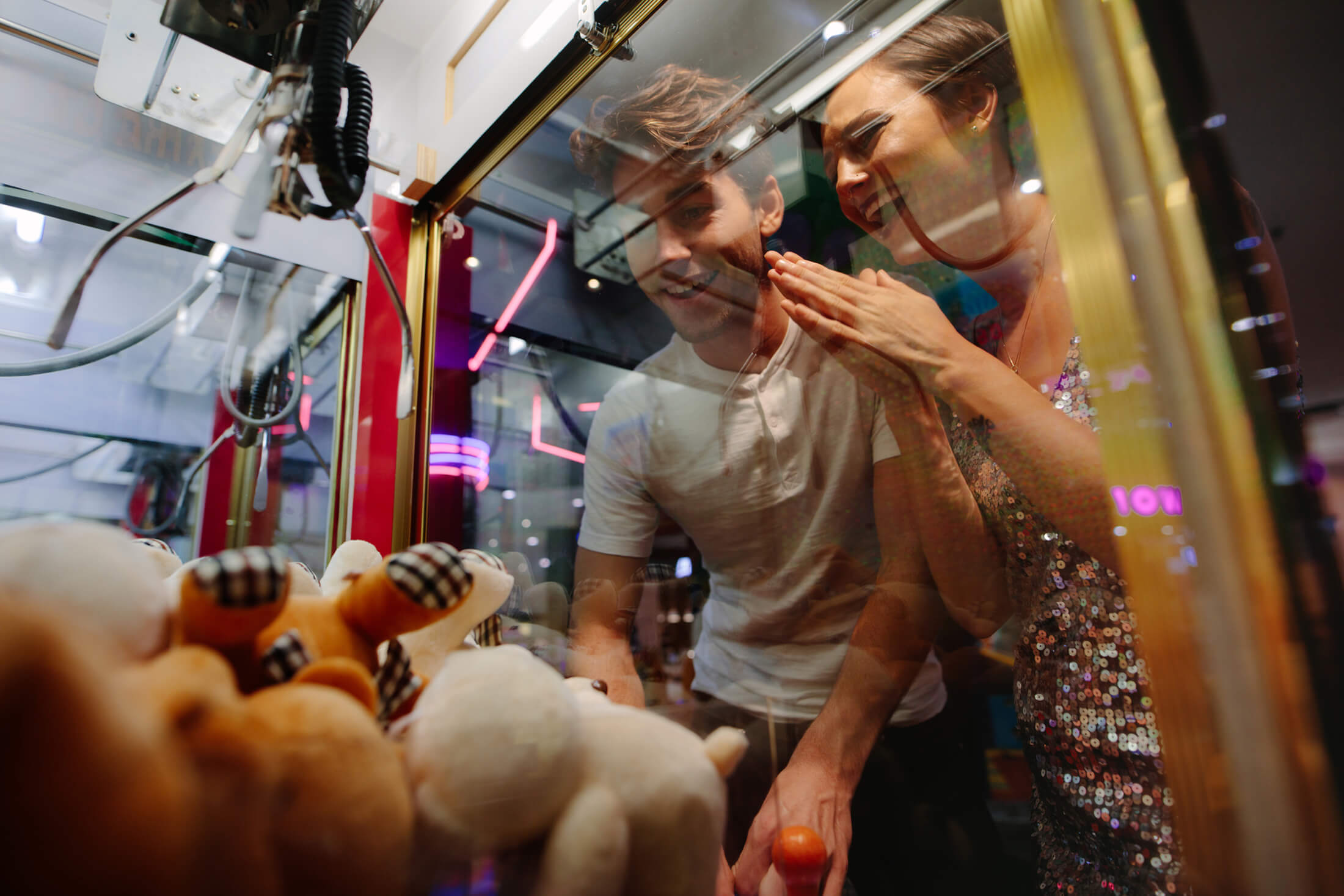 two teenagers trying to win a prize from the claw machine