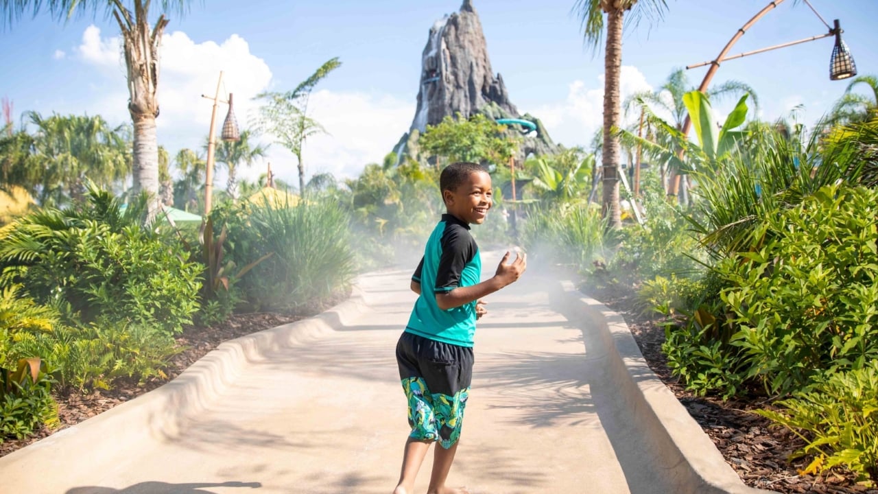 a child running down the path of an amusement park