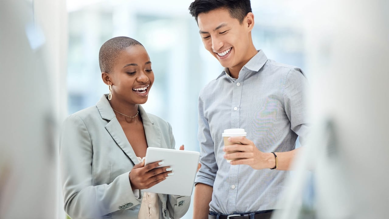 a man and woman having a conversation and lookign at an ipad
