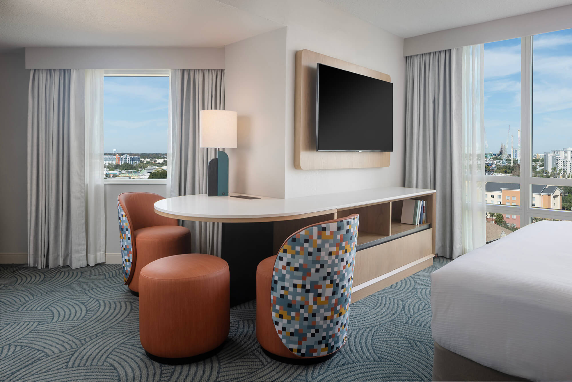 The work desk in a hotel room, surrounded by large windows