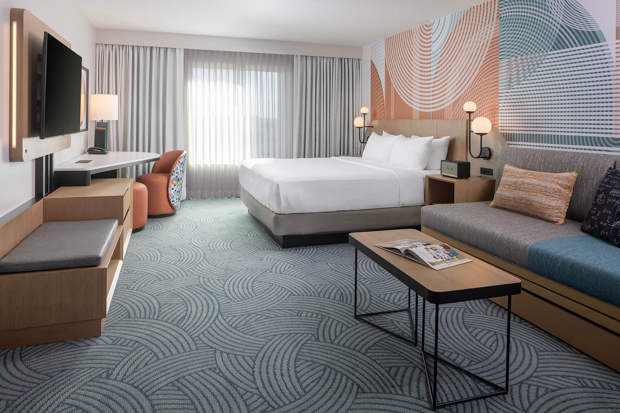 a spacious king bedroom with a large window at the end of the room. There is also a sofa bed with a coffee table