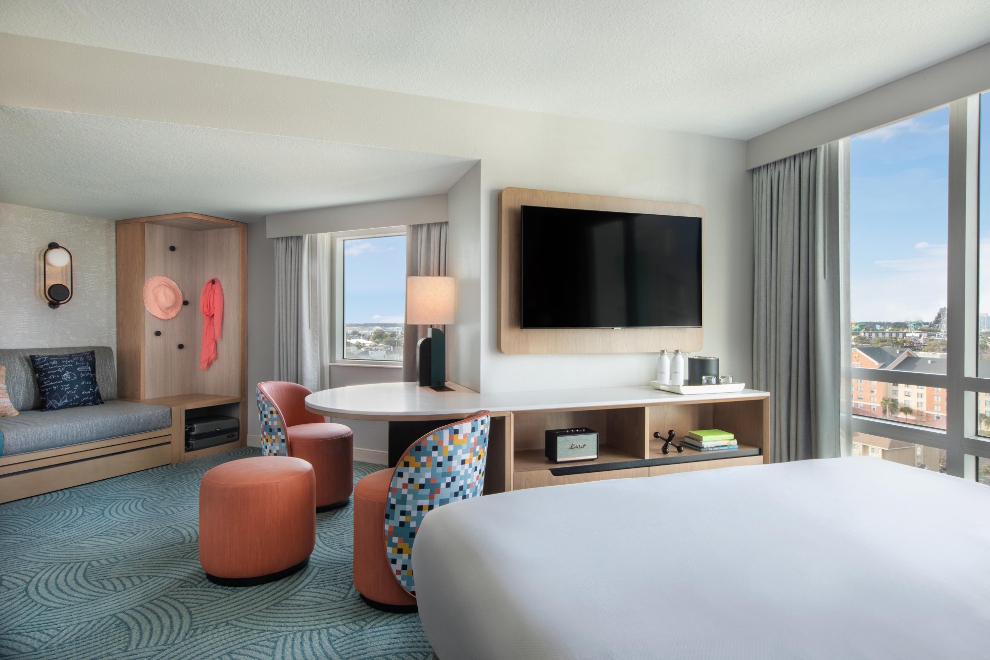 The interior of the Junior Suite at Hotel Landy. The room includes a large bed, workspace, flatscreen tv and bench.