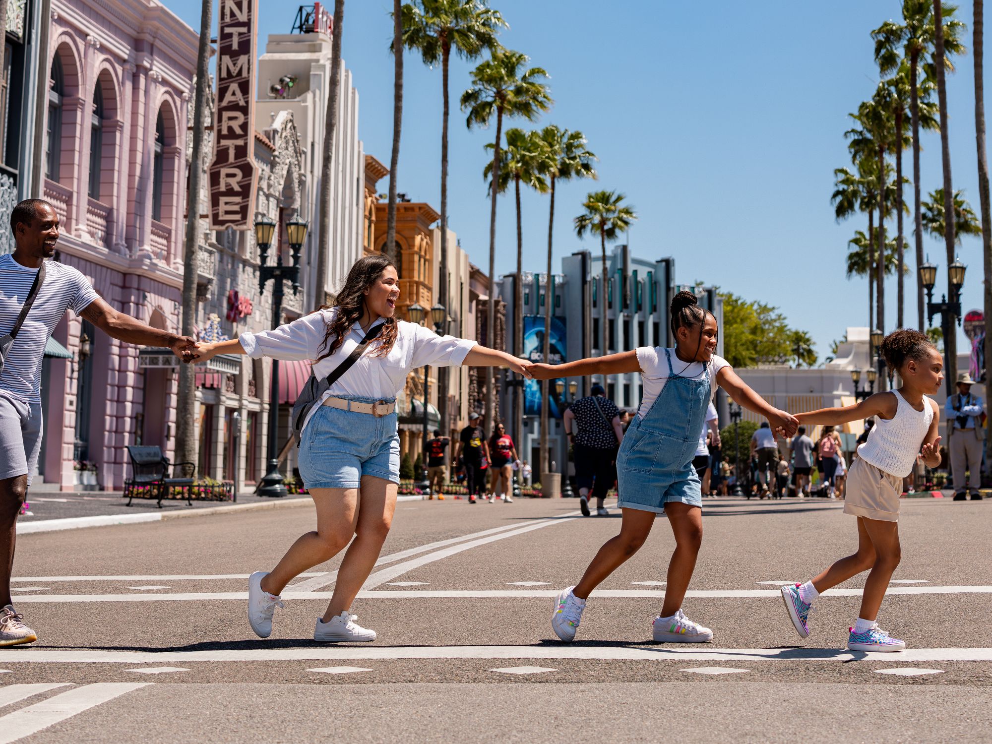 family holding hands crossing the street