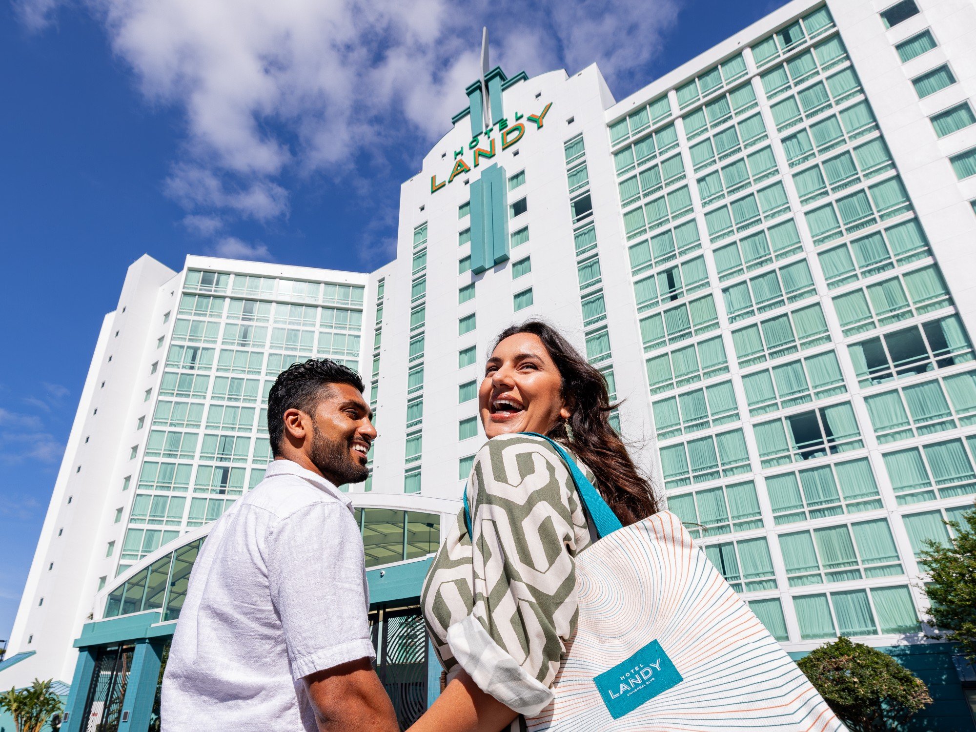 Couple holding hands in front of Hotel Landy