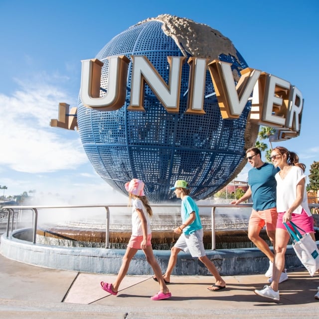 A family walking past the Universal globe