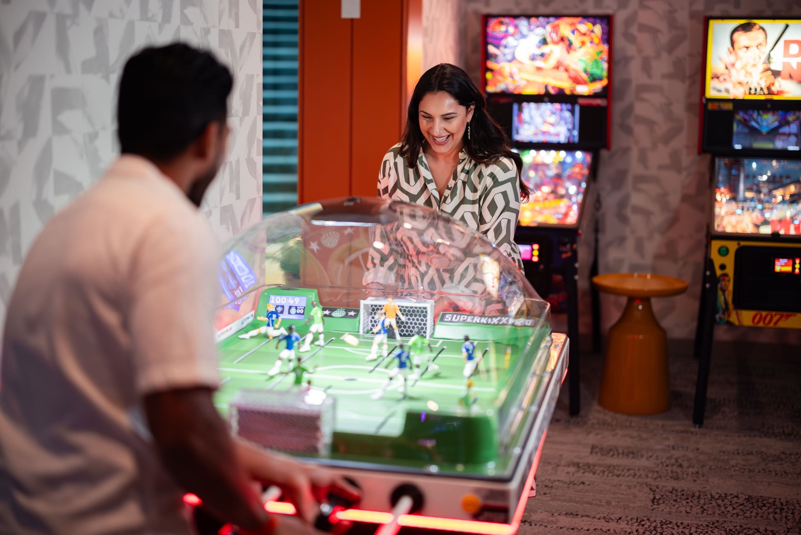 A couple playing soccer in an arcade