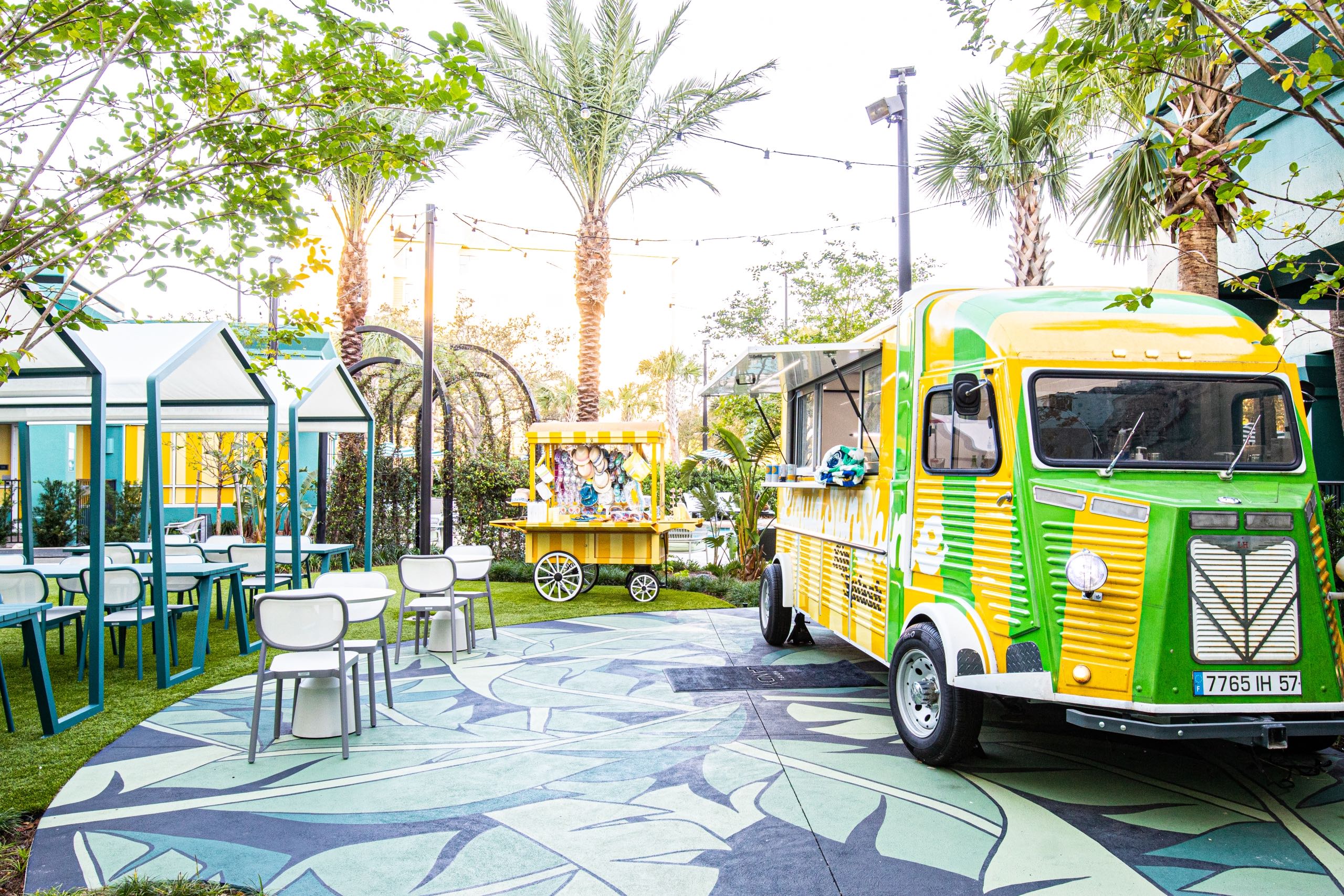An outdoor sitting area with a food truck and a souvenir cart