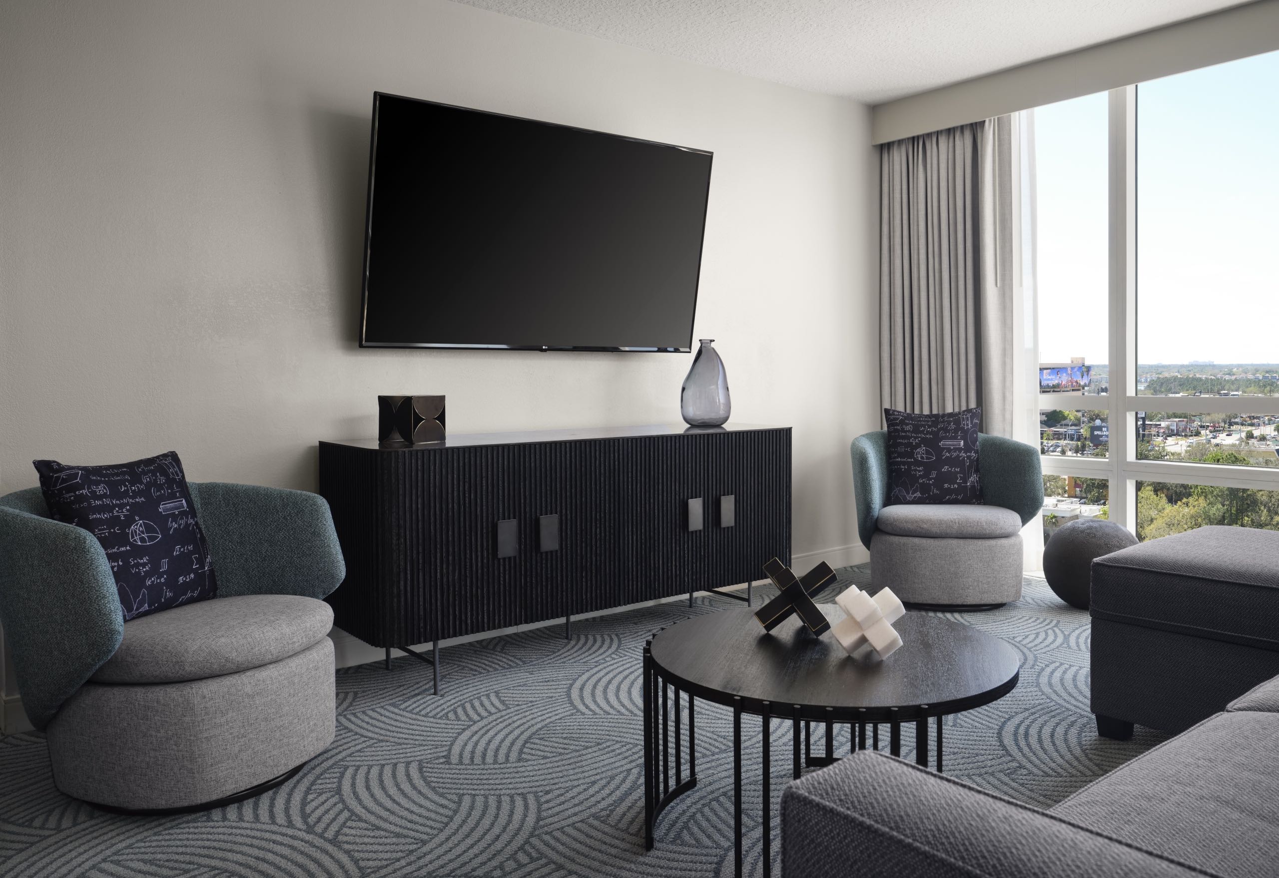 A room with a large television and seating area