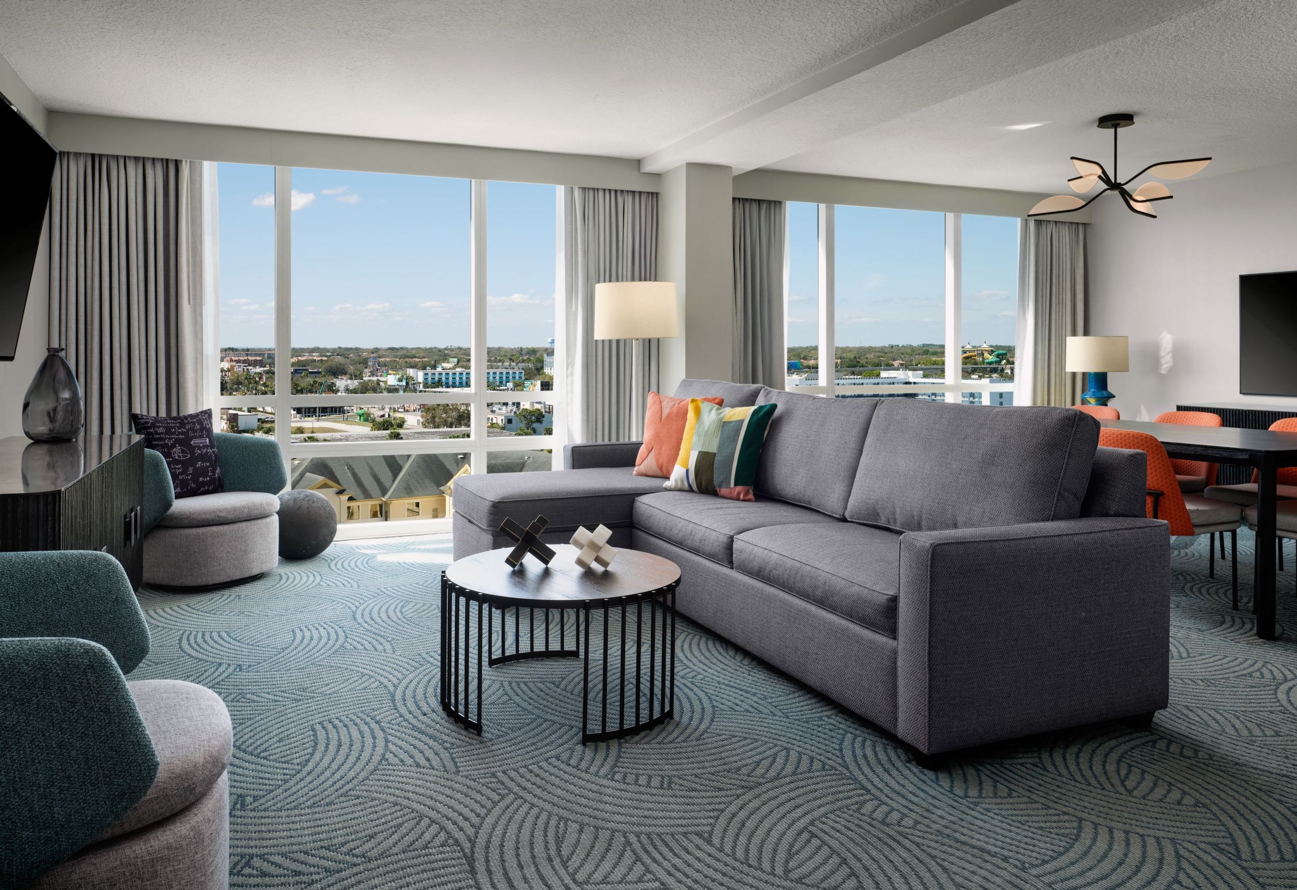 A room with a large television and seating area