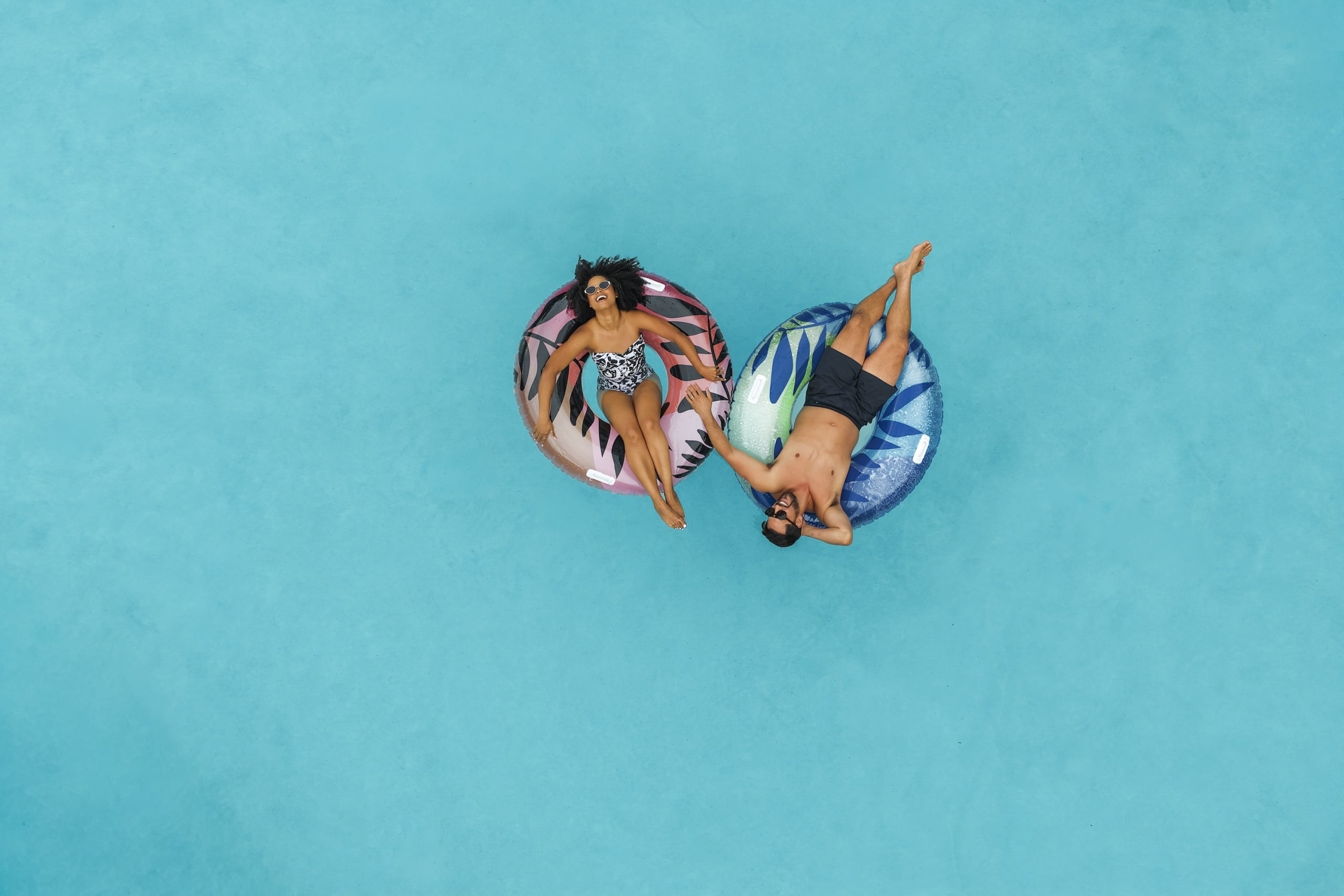A couple lounge in the Hotel Landy Pool as they float on a inner tubes